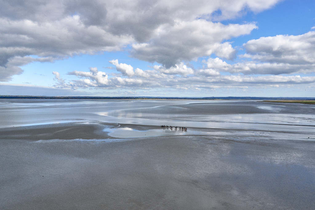Normandy landscape and the people walking on the bay in the low tides